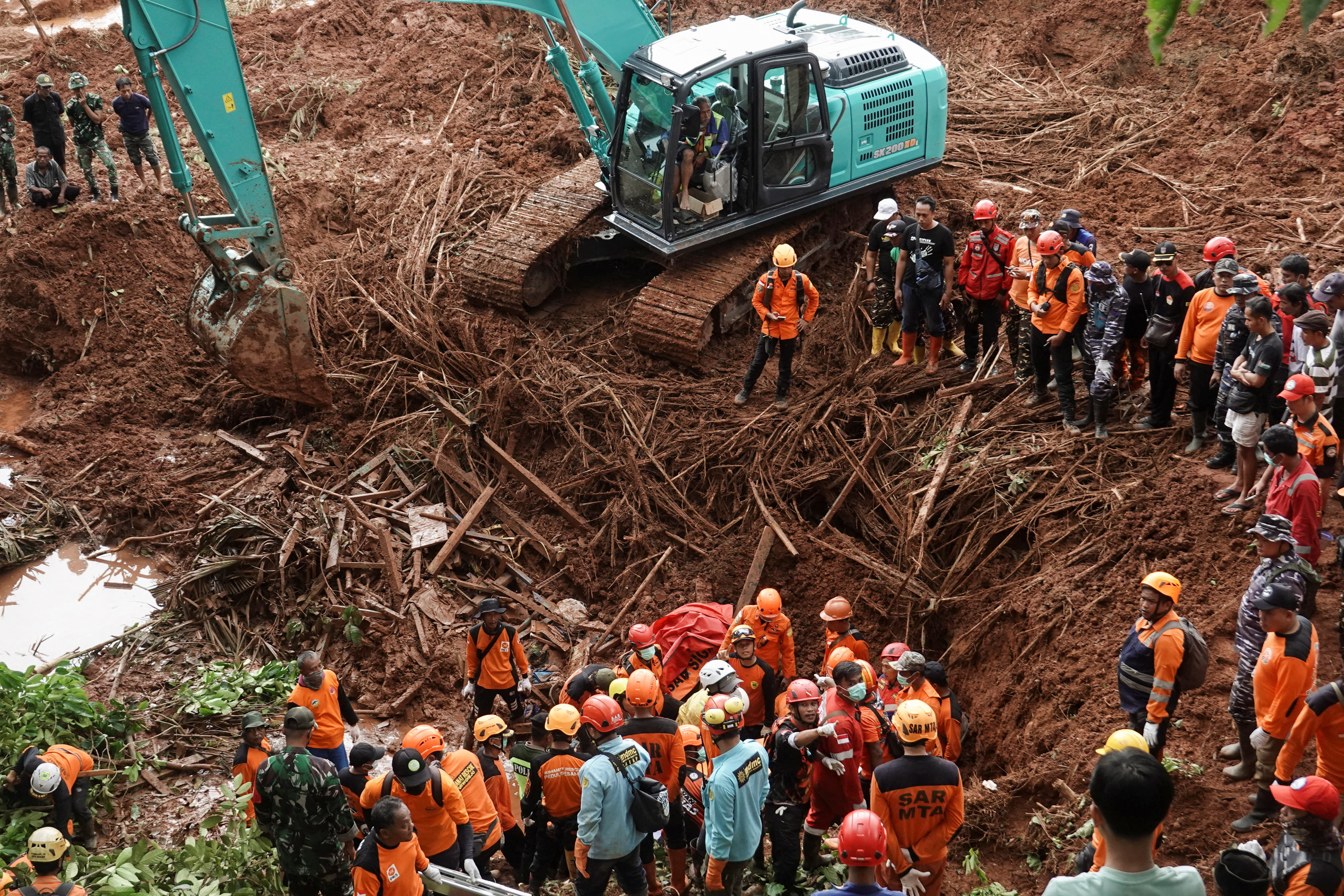 Indonesian rescue members search for victims at the site of a landslide, which hit Cibeunying village on November 13, in Cilacap