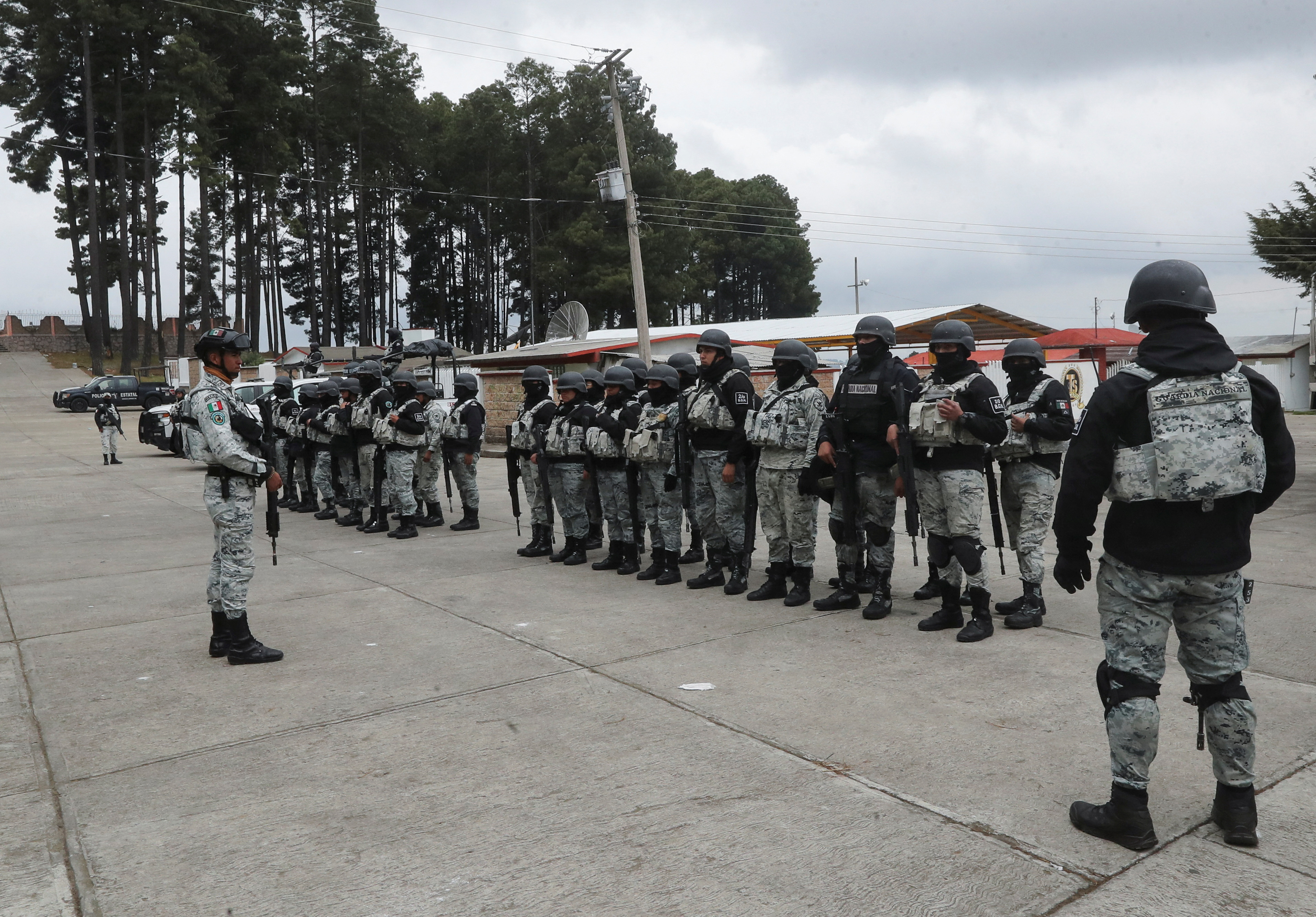 Officers of the National Guard stand in formation at an area following villagers' bloody takedown of extortionists in Texcapilla