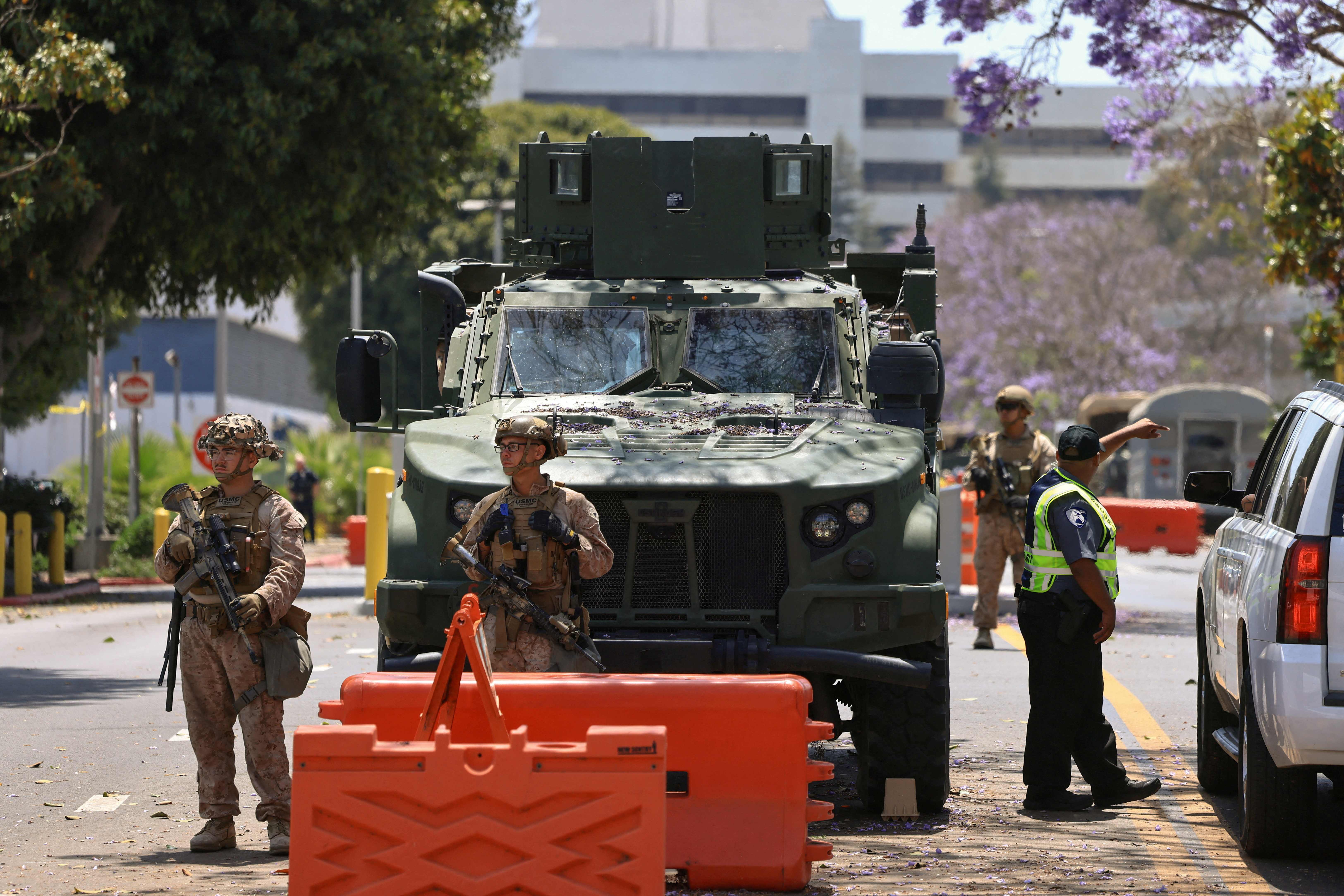 FILE PHOTO: U.S. Marines stand watch at a checkpoint as they guard a federal building, in Los Angeles