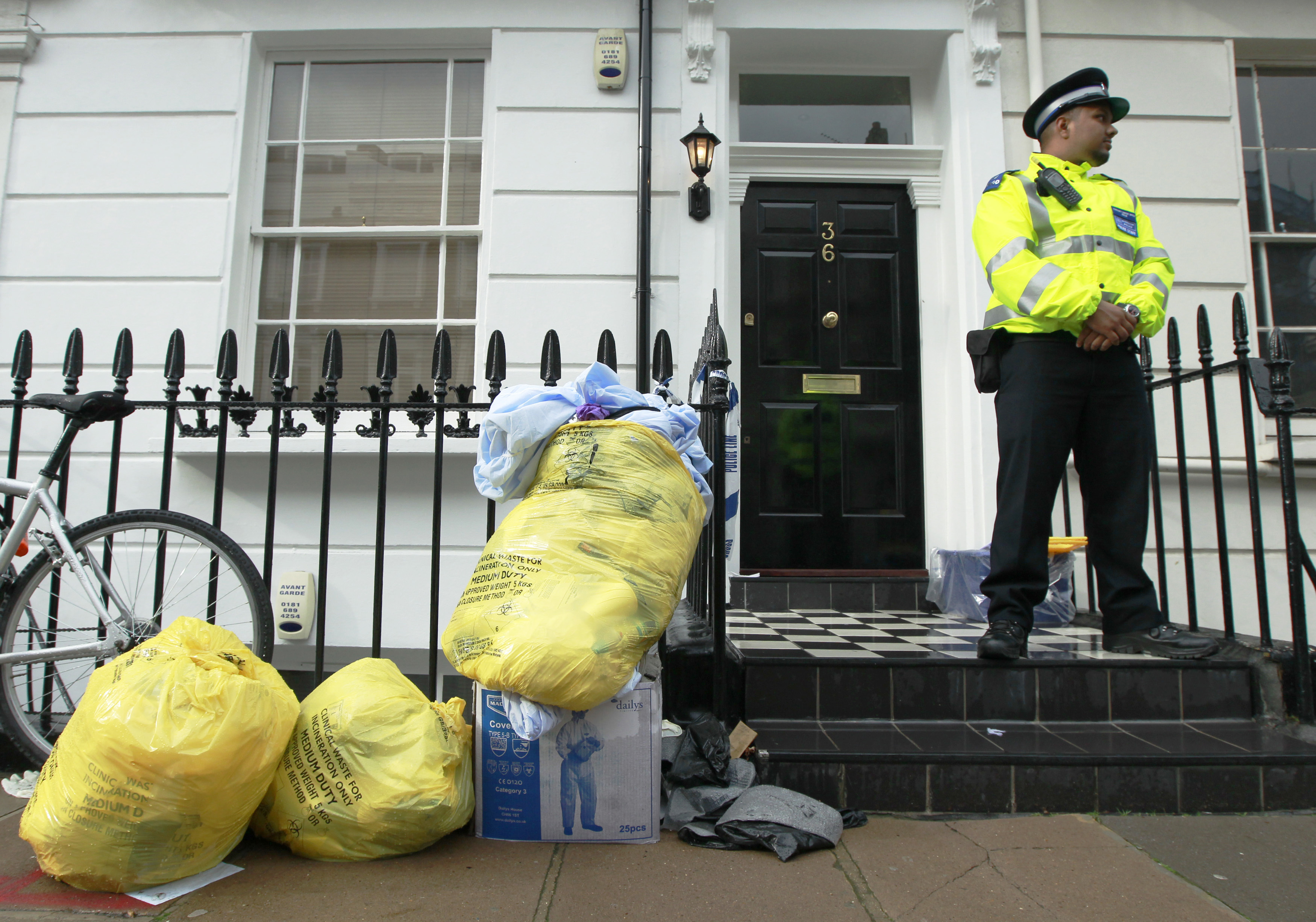 A police support officer guards a property in Pimlico in central London