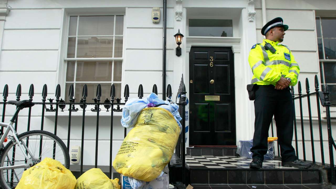 A police support officer guards a property in Pimlico in central London