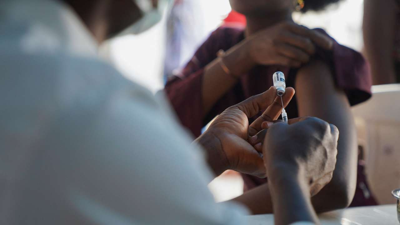 A Nigerian health official prepares to administer a mpox vaccination to a woman, at Federal Medical Center in Abuja