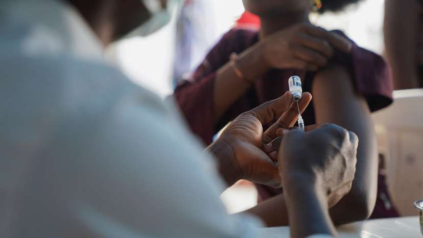 A Nigerian health official prepares to administer a mpox vaccination to a woman, at Federal Medical Center in Abuja
