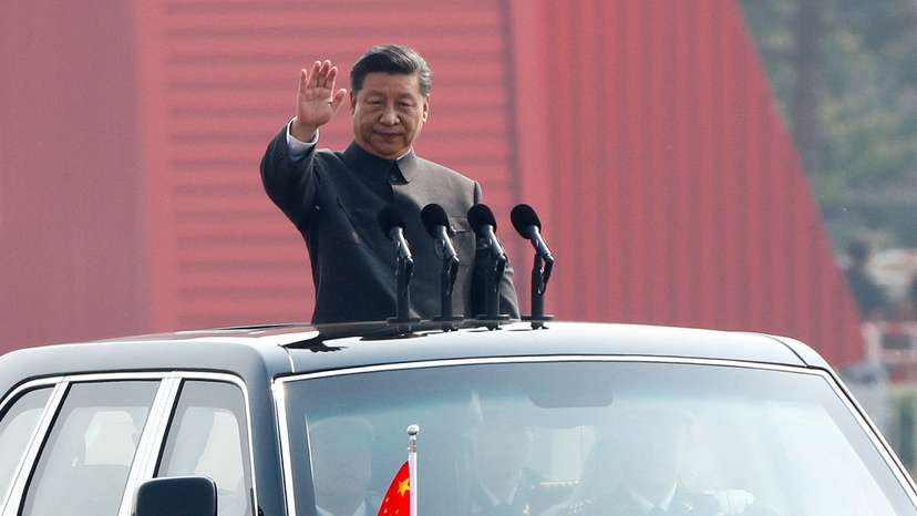 FILE PHOTO: Chinese President Xi Jinping waves from a vehicle as he reviews the troops at a military parade marking the 70th founding anniversary of People's Republic of China
