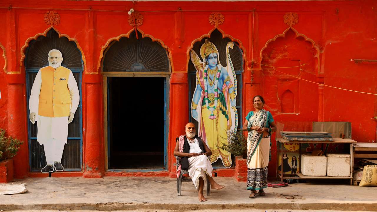 People are seen at the premises of a temple, next to the cutouts of India's Prime Minister Narendra Modi and the Hindu Lord Ram, in Ayodhya
