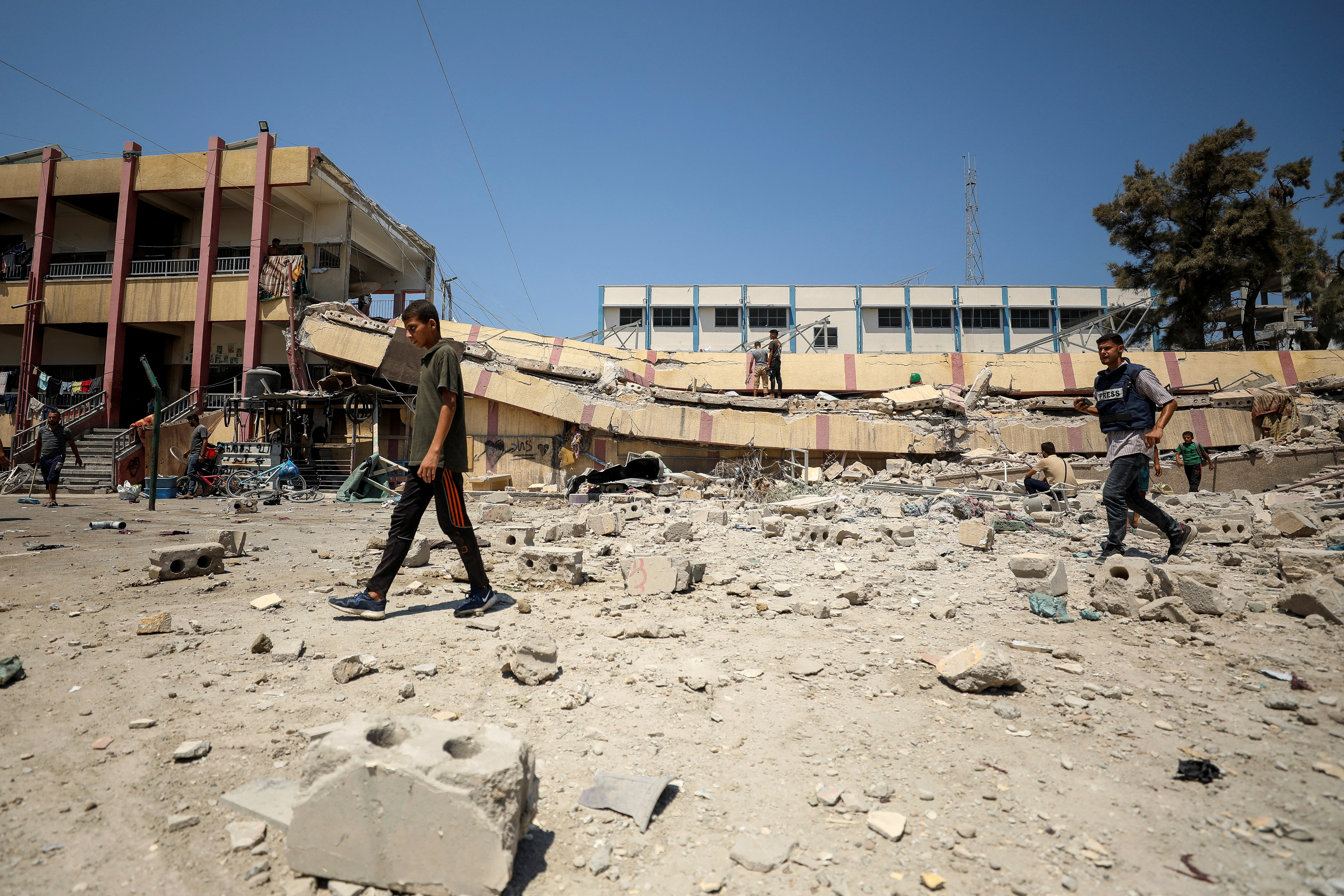 Palestinians inspect a school sheltering displaced people after it was hit by an Israeli strike, in Gaza City