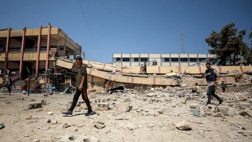 Palestinians inspect a school sheltering displaced people after it was hit by an Israeli strike, in Gaza City