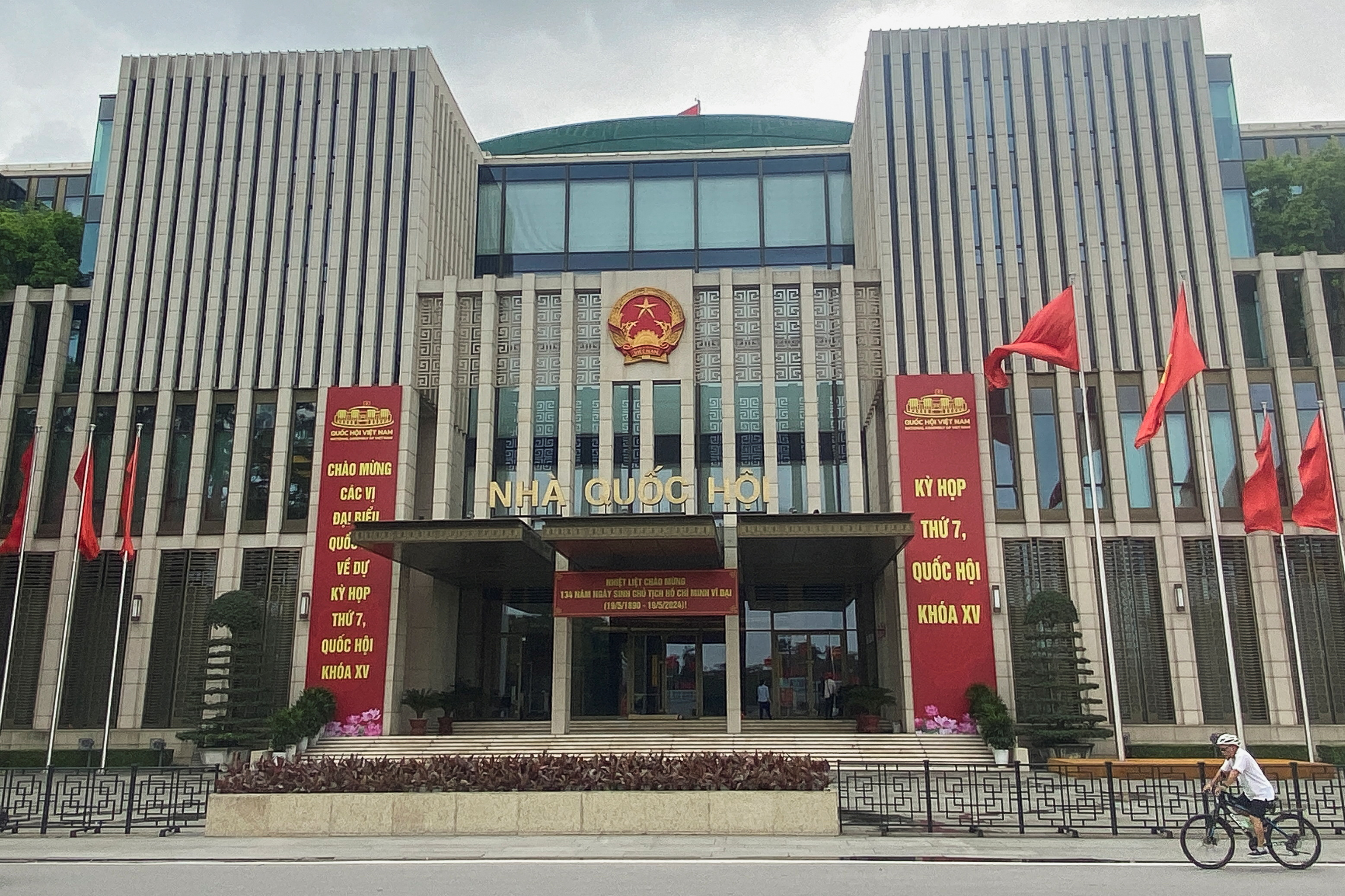 A man cycles in front of the National Assembly Building of Vietnam, in Hanoi