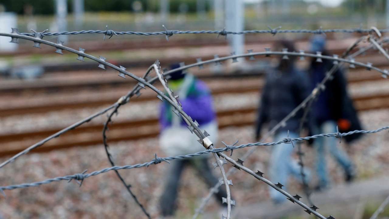 FILE PHOTO: Razor-wire frames migrants who walk near train tracks which lead to the Channel Tunnel in Frethun, near Calais