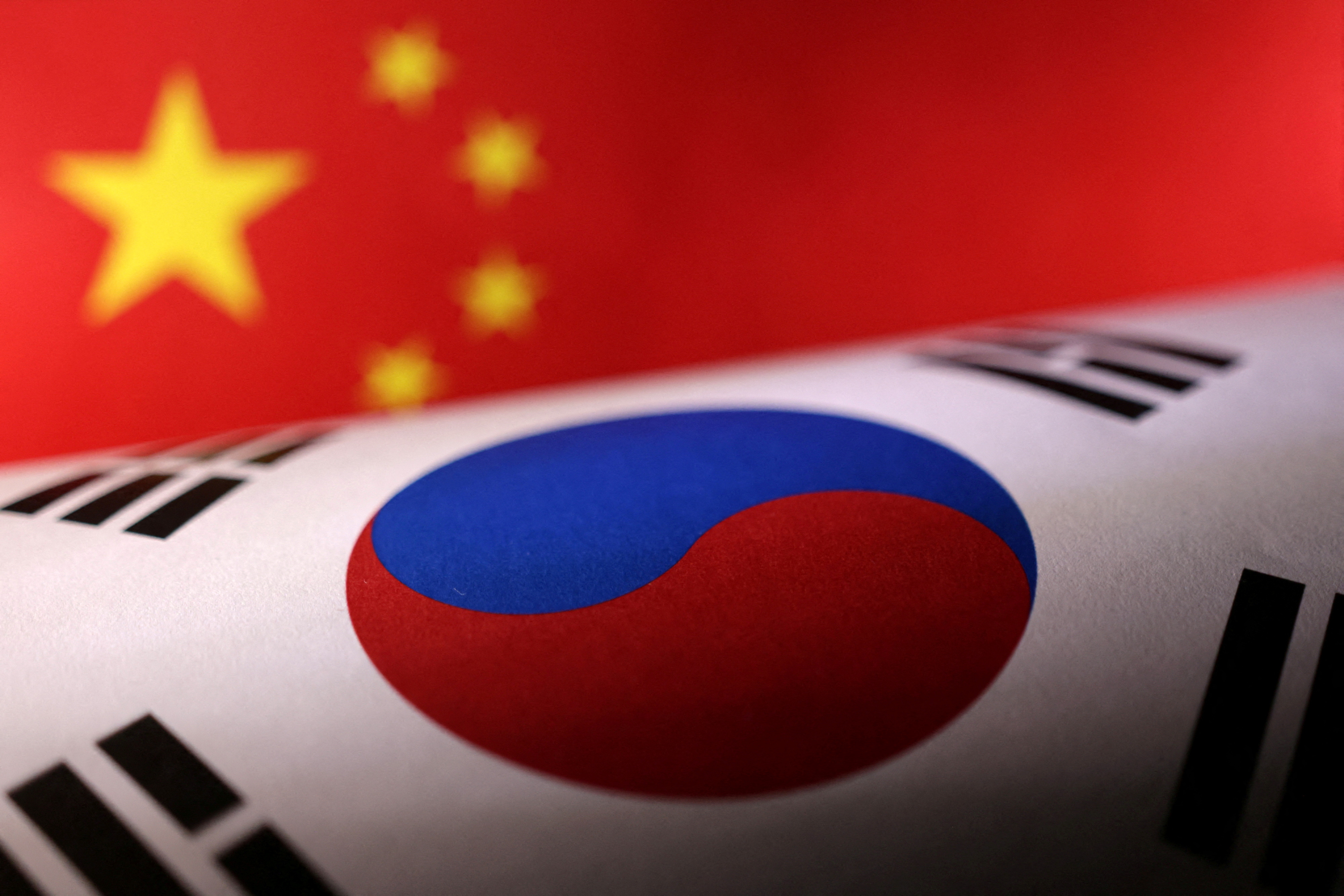 Illustration shows printed Chinese and South Korean flags
