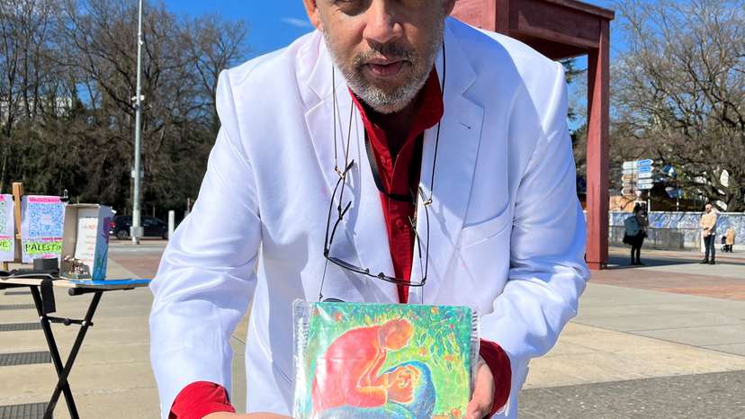 FILE PHOTO: Bruno Donat holds up a painting by a Gazan artist during a hunger strike for children affected during the conflict between Israel and Hamas, in Geneva