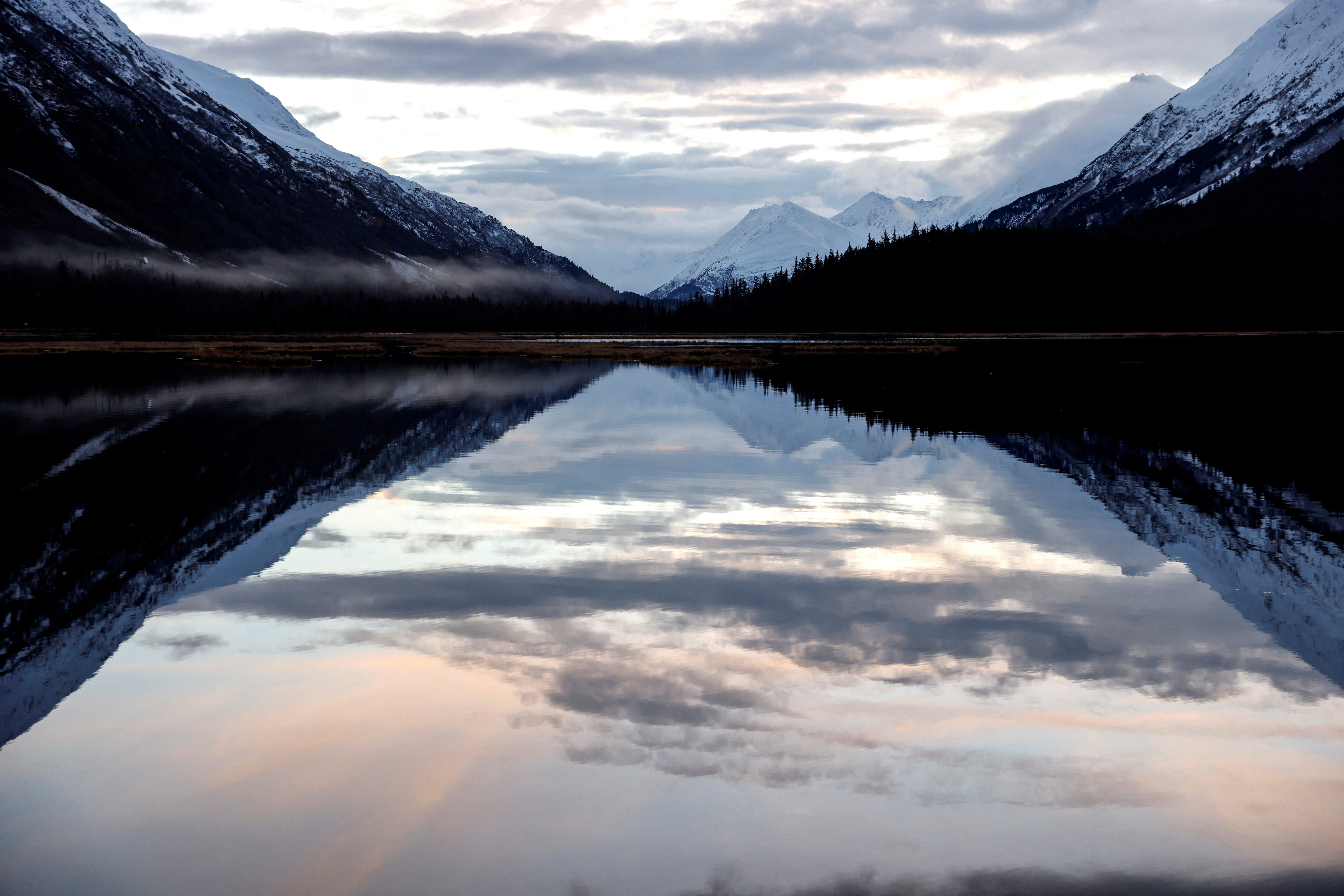 FILE PHOTO: Snow capped mountains are reflected in Kenai Lake outside of Cooper Landing in Anchorage