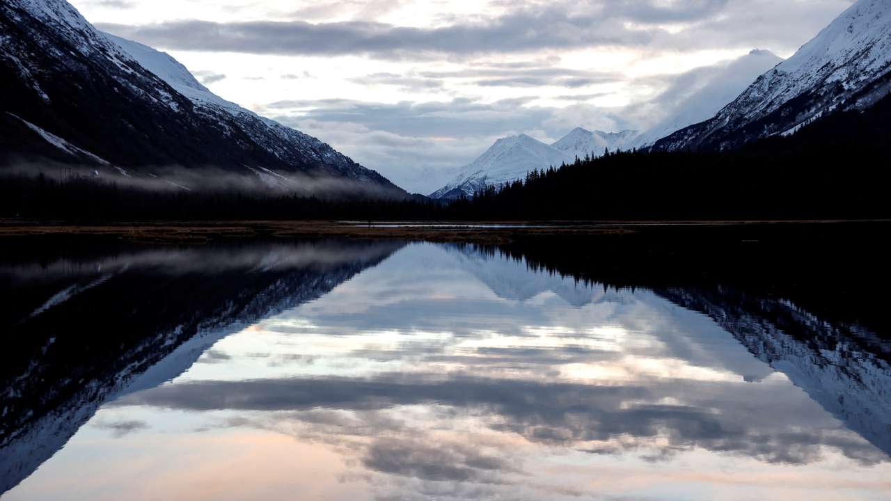 FILE PHOTO: Snow capped mountains are reflected in Kenai Lake outside of Cooper Landing in Anchorage
