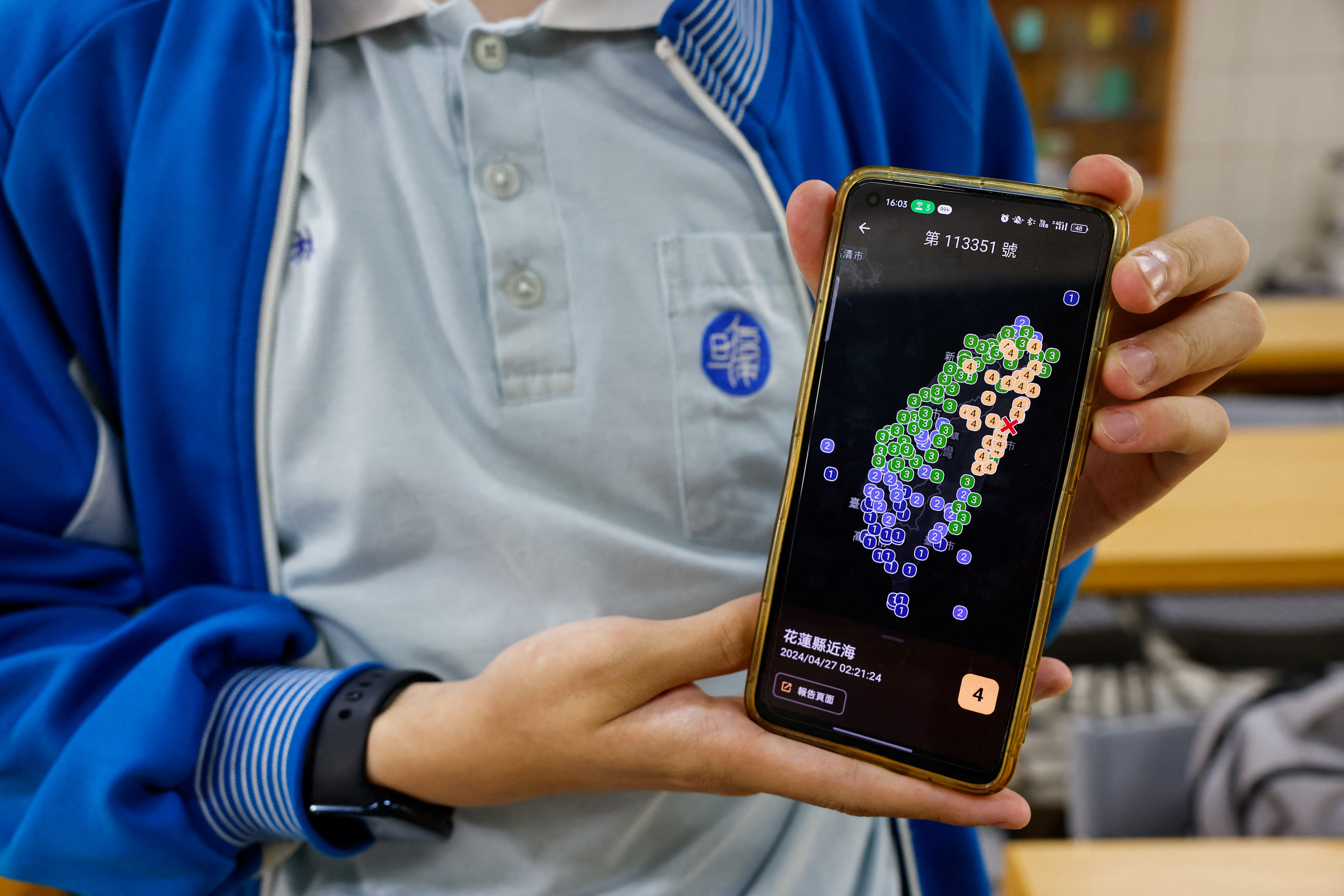 Lin Ruei, 17, co-founder of Exptech and Disaster Prevention Information Platform app (DPIP) poses for a photo while showing his app, in Taoyuan