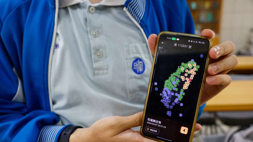 Lin Ruei, 17, co-founder of Exptech and Disaster Prevention Information Platform app (DPIP) poses for a photo while showing his app, in Taoyuan