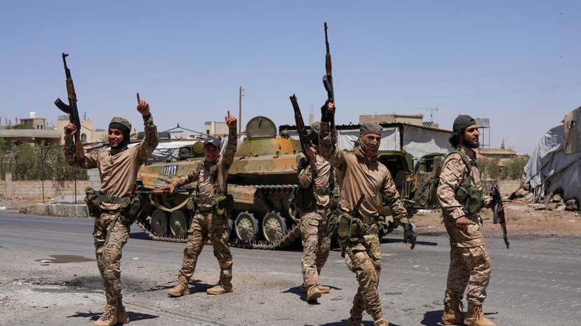 FILE PHOTO: Syrian security forces walk together along a street in Sweida