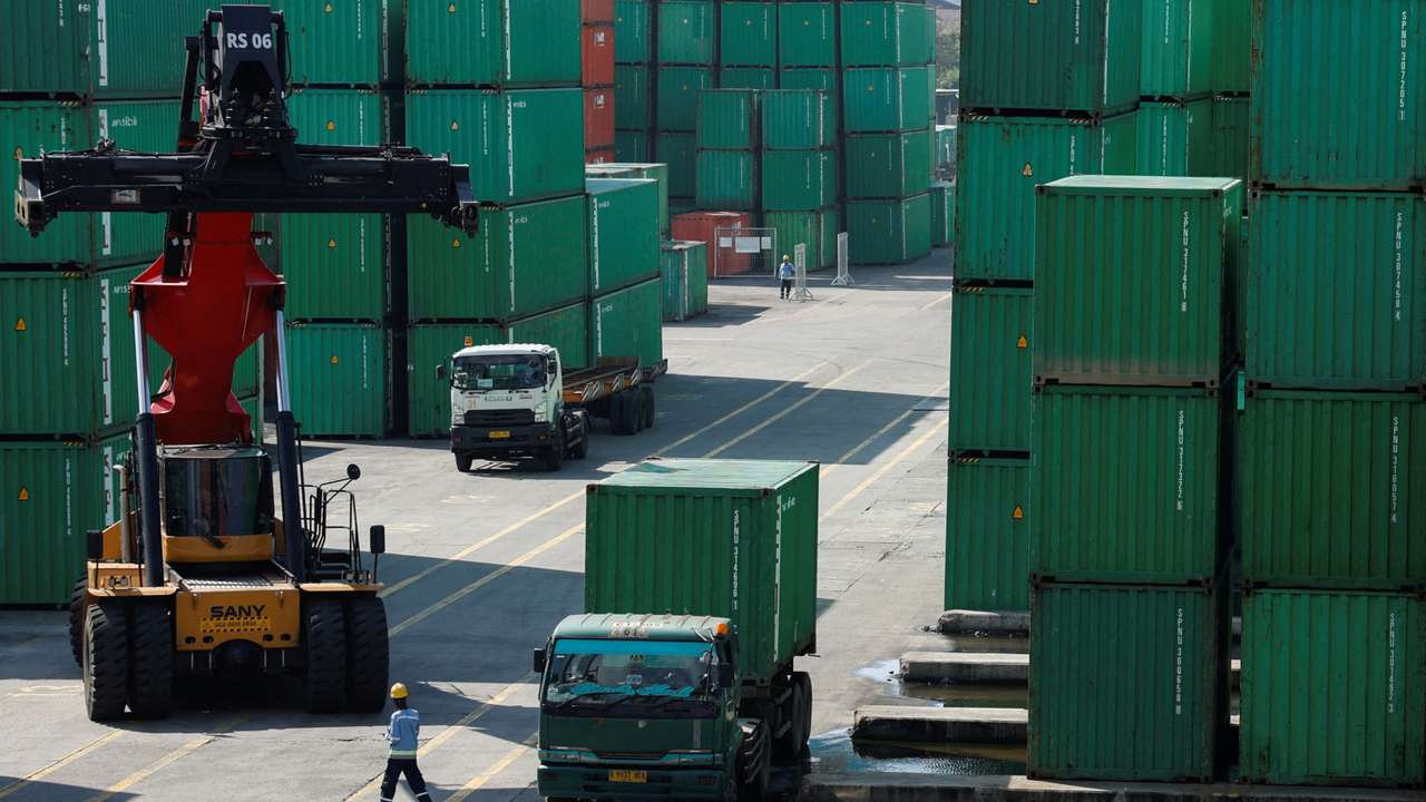 FILE PHOTO: A container truck is unloaded from a truck at Tanjung Priok Port, in North Jakarta
