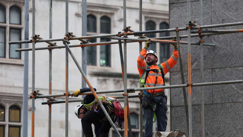 Construction workers work on a scaffolding at an office building