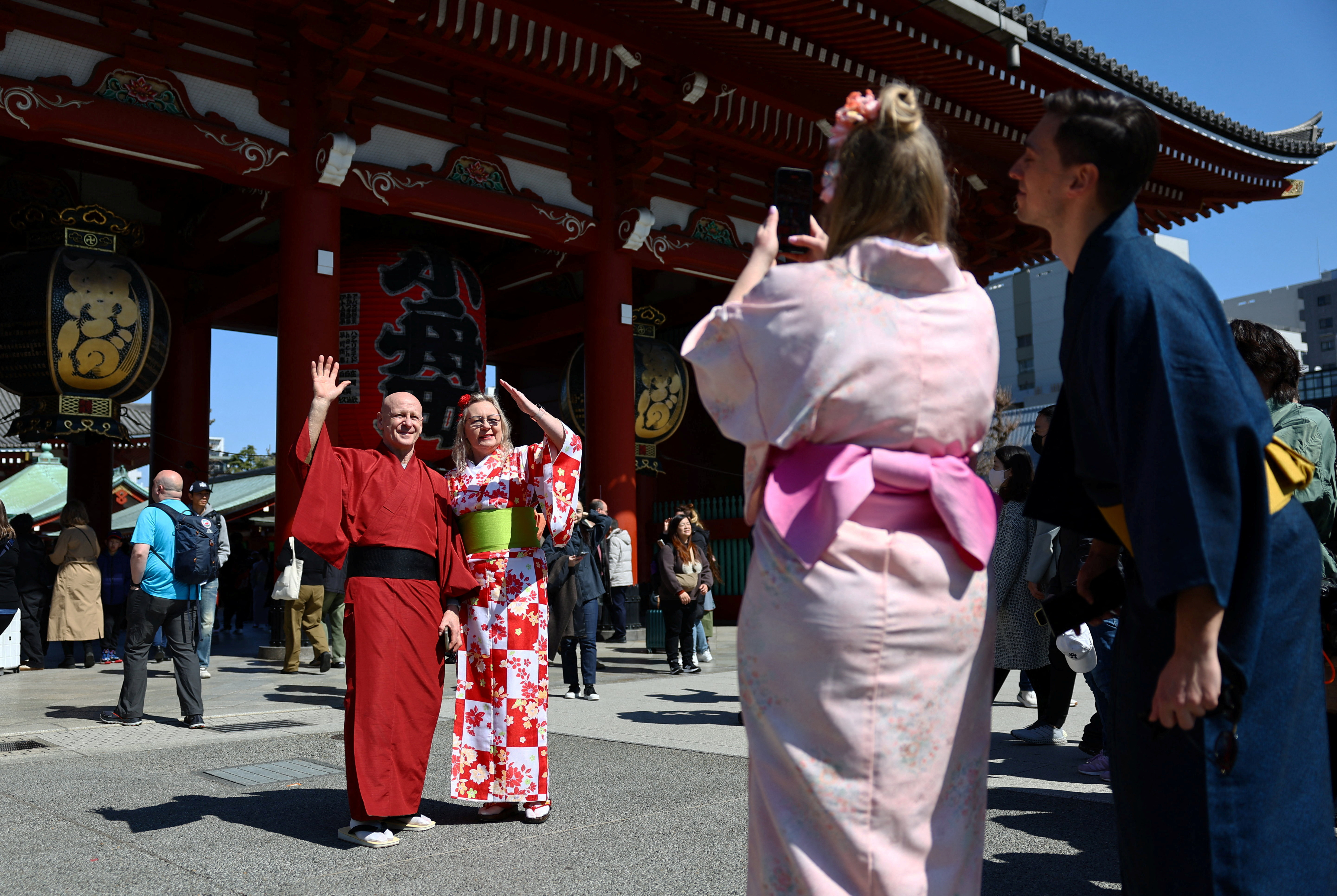Tourists pose for a photograph near Sensoji temple at Asakusa district in Tokyo