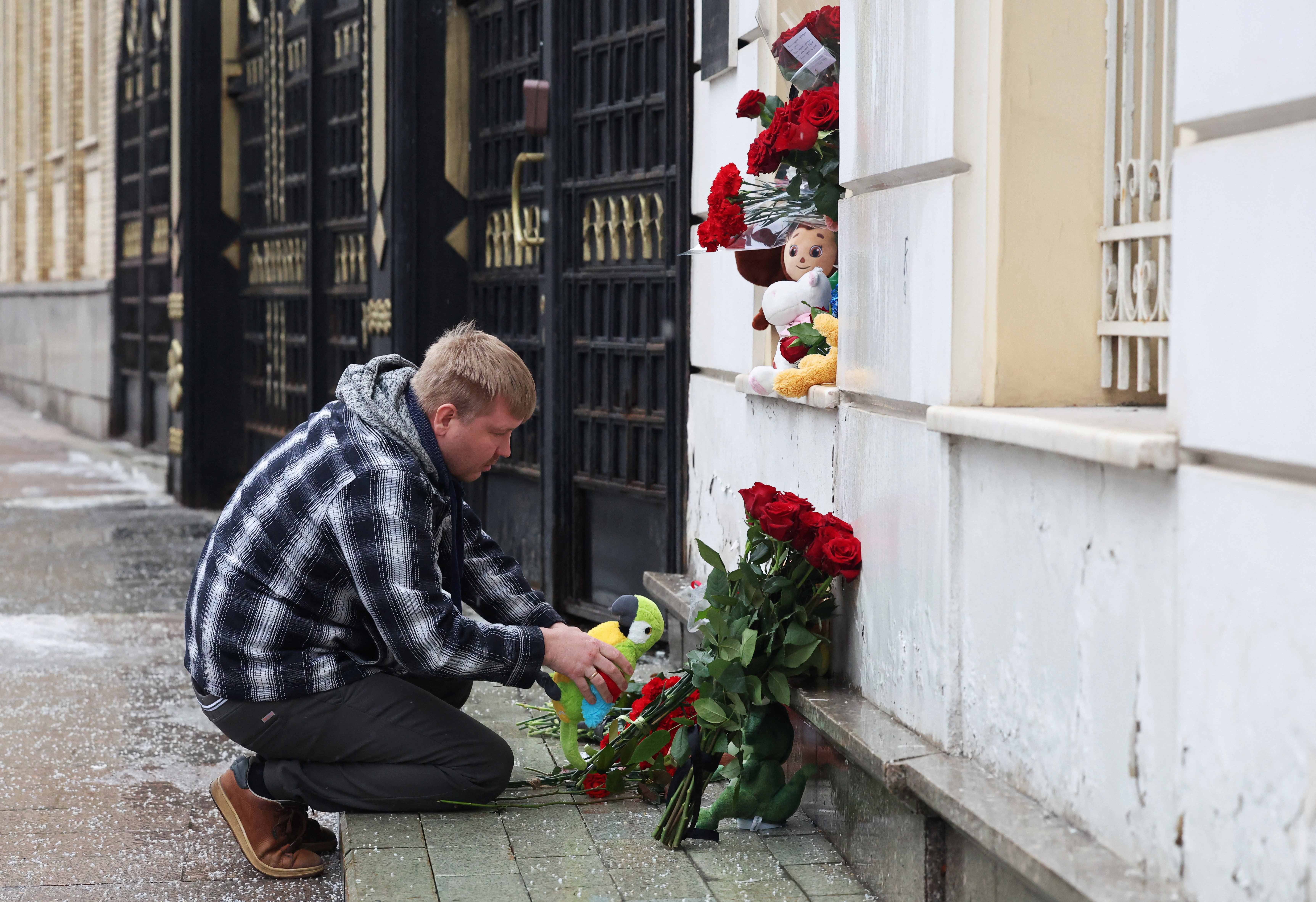 People bring flowers and toys to the Iranian embassy in Moscow