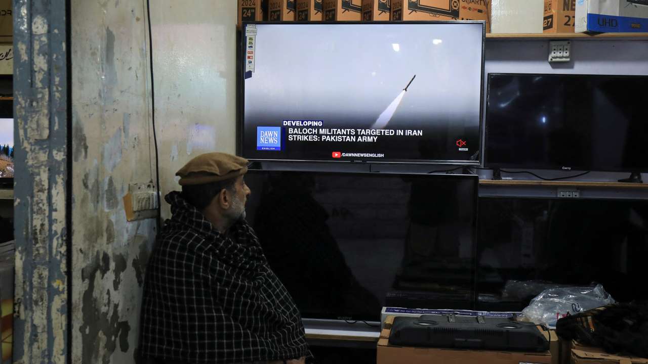 A man watches a news channel on television inside a shop after the Pakistani foreign ministry said the country conducted strikes inside Iran targeting separatist militants, in Peshawar