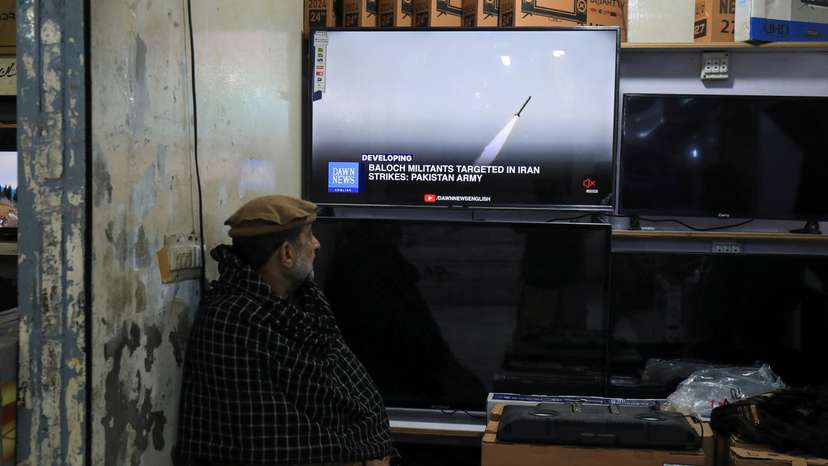 A man watches a news channel on television inside a shop after the Pakistani foreign ministry said the country conducted strikes inside Iran targeting separatist militants, in Peshawar