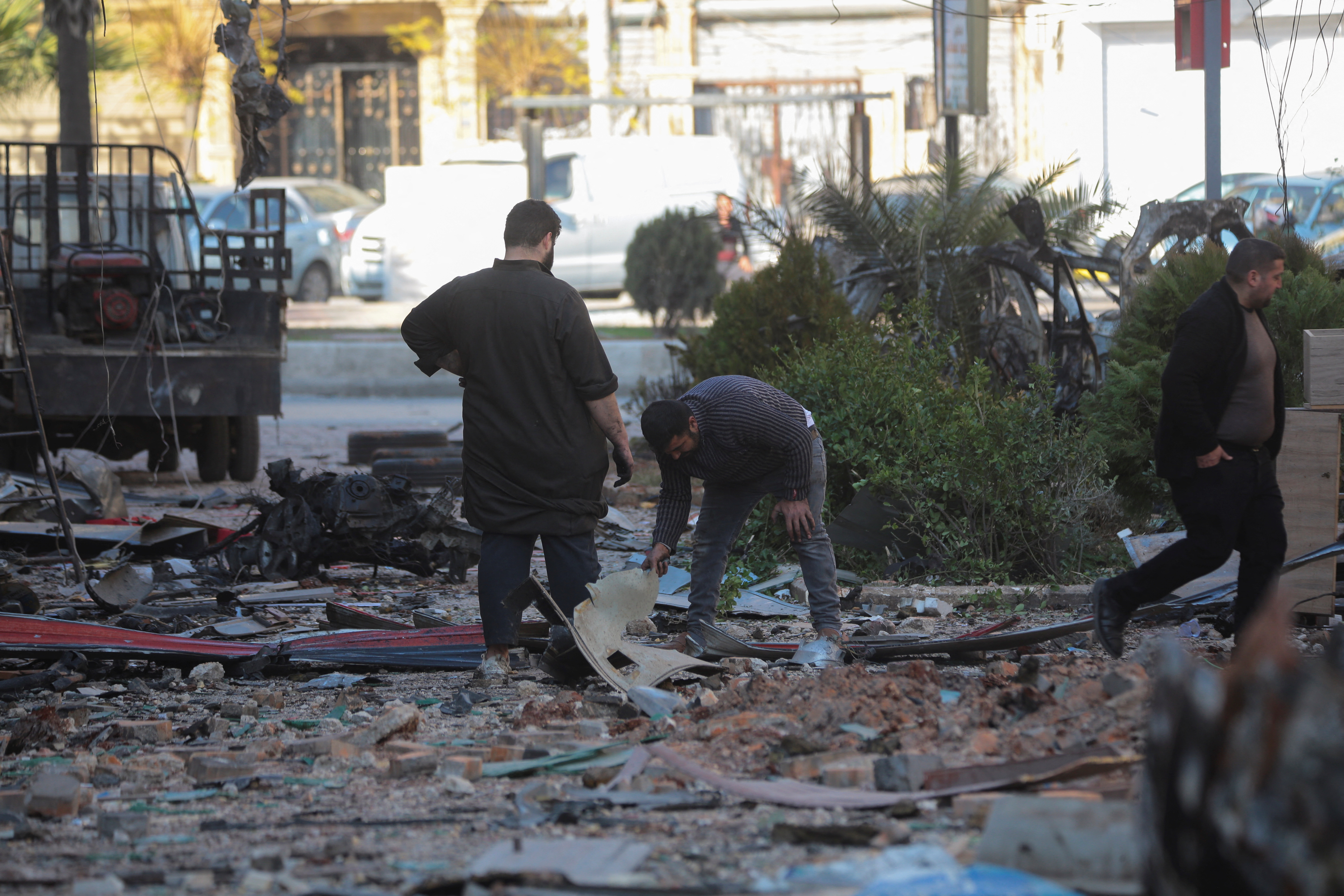 People inspect a damaged site in Aleppo