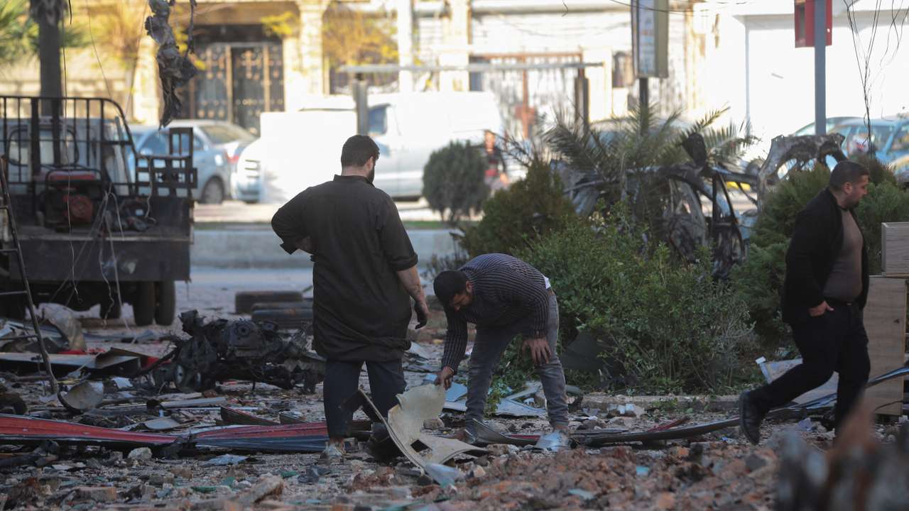 People inspect a damaged site in Aleppo