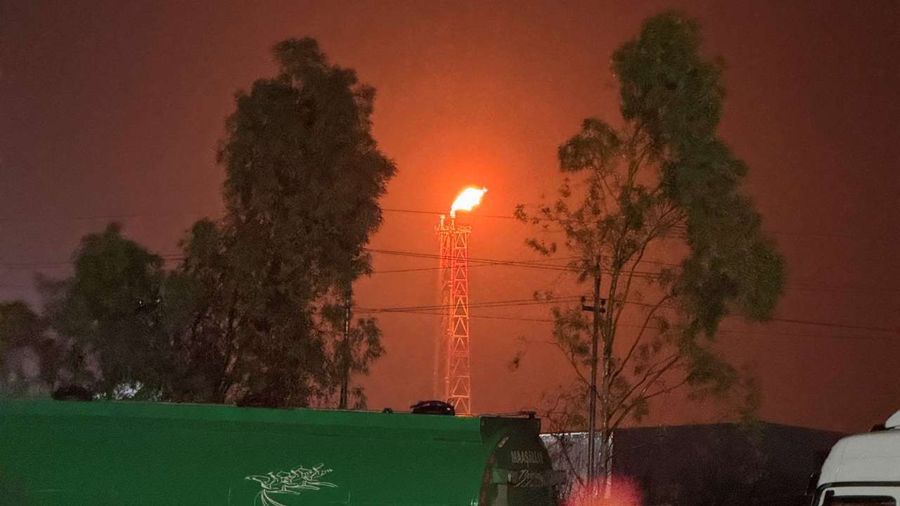 A gas flare burns at the Lanaz refinery after it was targeted by a drone strike, in Erbil