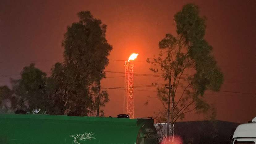 A gas flare burns at the Lanaz refinery after it was targeted by a drone strike, in Erbil