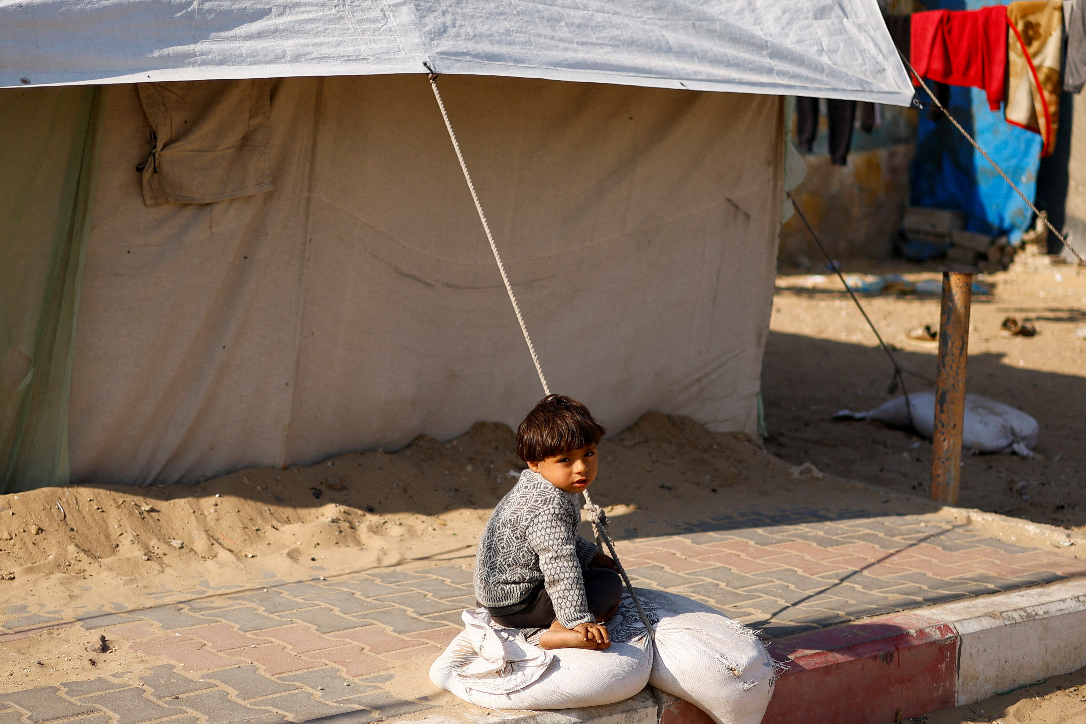 Displaced Palestinians, who fled their houses due to Israeli strikes, shelter at a tent camp, in Rafah
