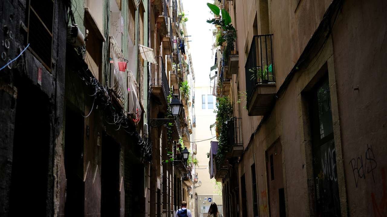 Tourists walk with their suitcases in Gothic Quarter, in Barcelona