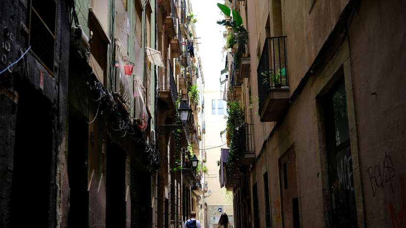 Tourists walk with their suitcases in Gothic Quarter, in Barcelona