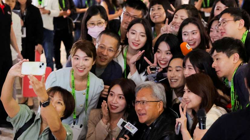 FILE PHOTO: Nvidia CEO Jensen Huang poses for selfie with members of the media at COMPUTEX forum in Taipei