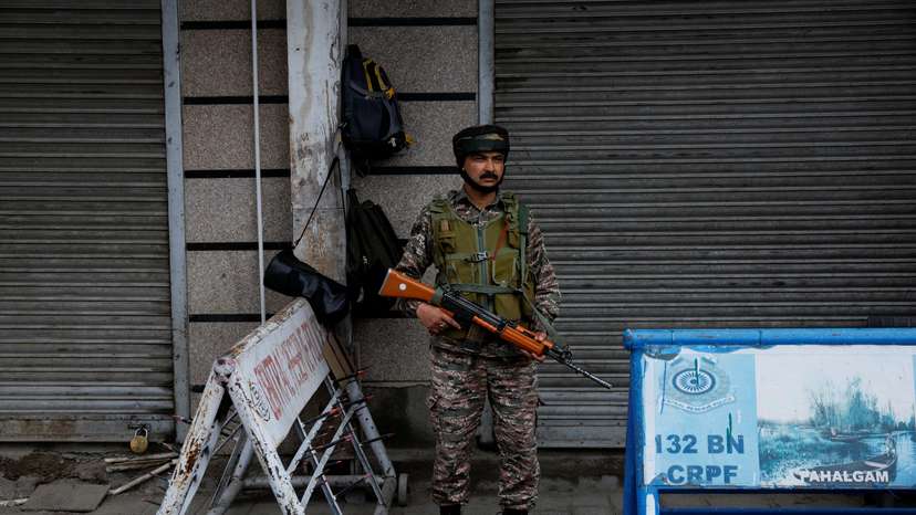 An Indian security personnel stands guard on a street, following clashes between India and Pakistan, in Srinagar