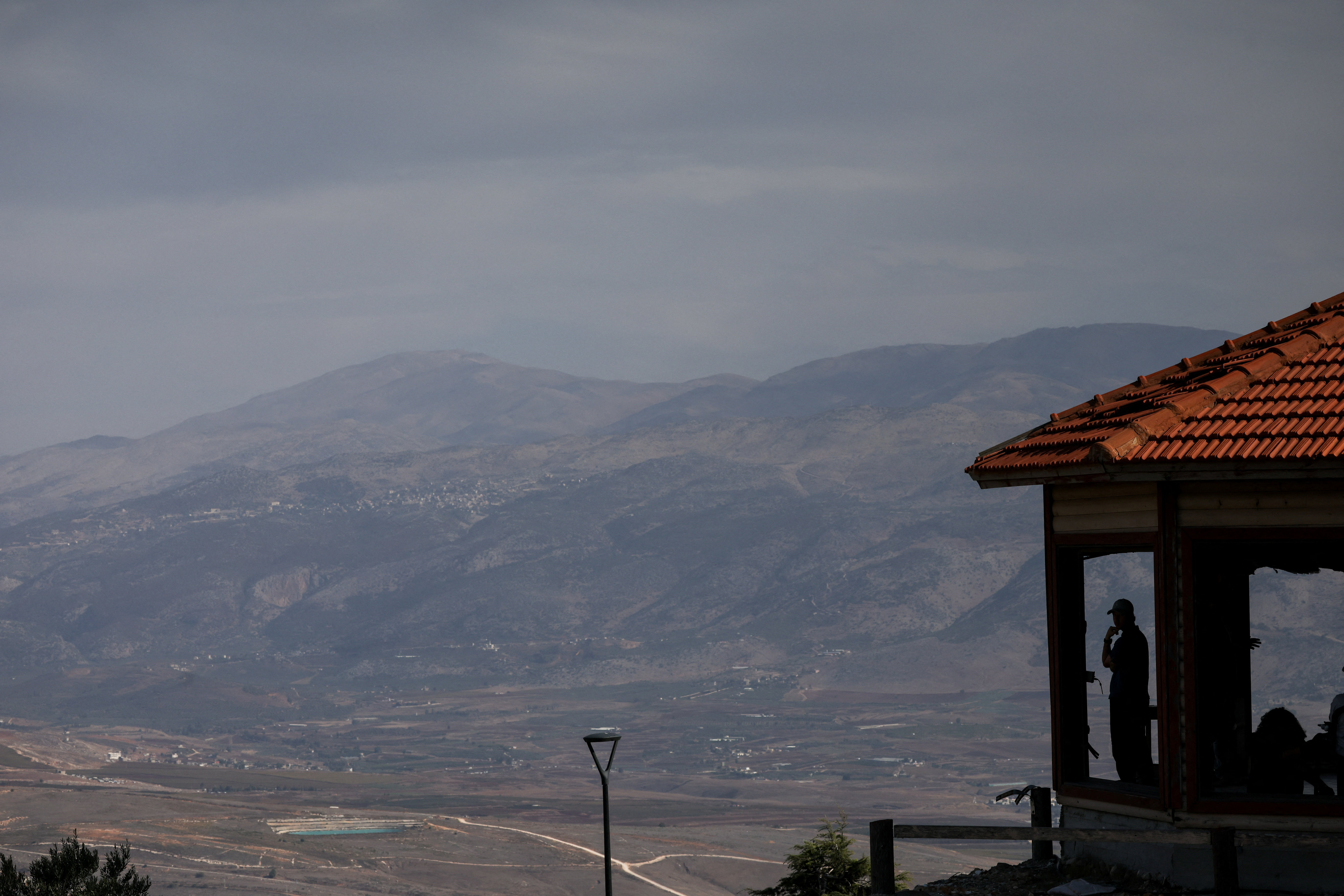 Israeli citizen looks out from a viewpoint towards Lebanon as seen from northern Israel
