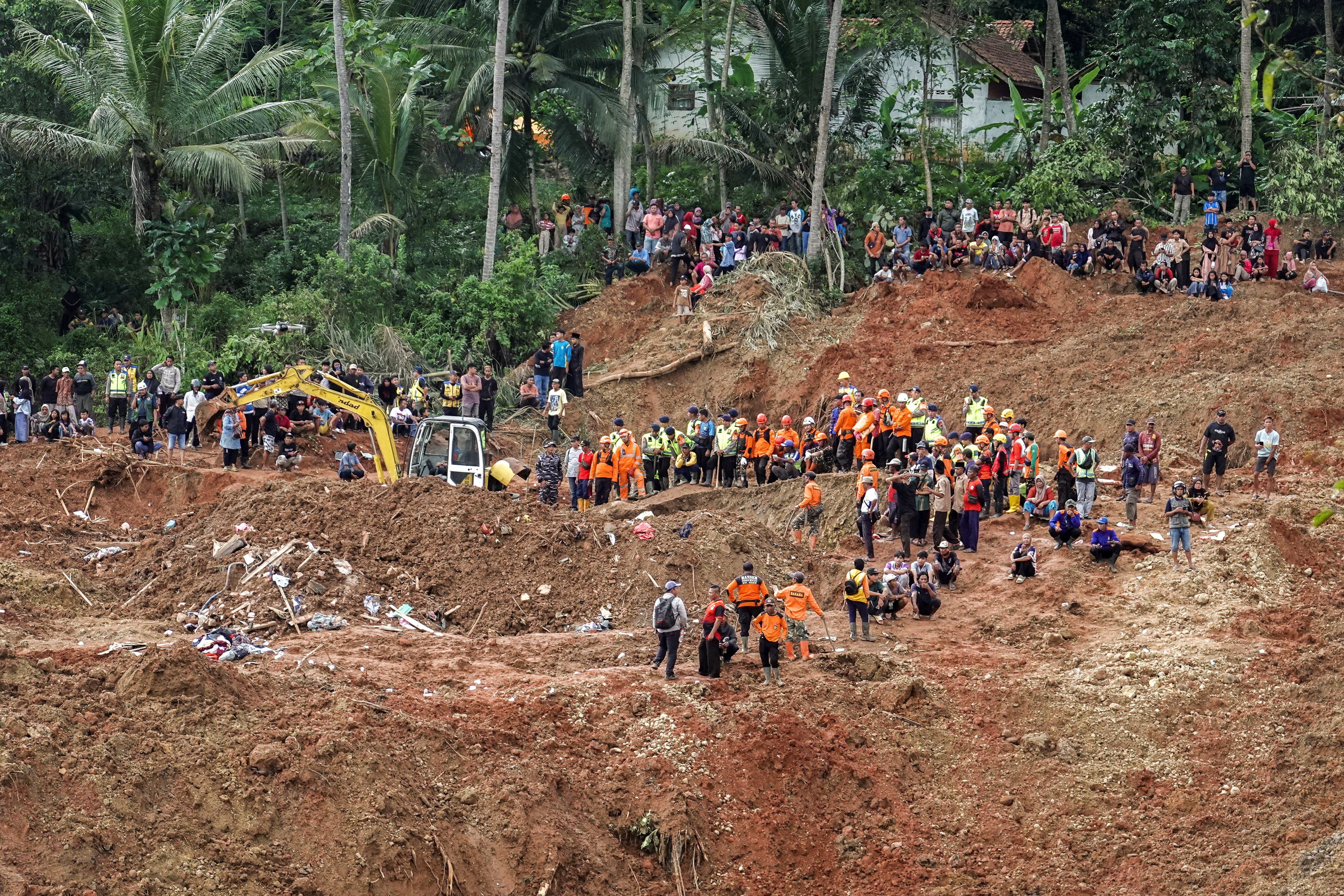 Indonesian rescue members search for victims at the site of a landslide, which hit Cibeunying village on November 13, in Cilacap