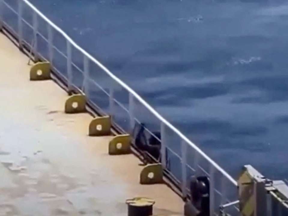 A person boards a shipping vessel MV Abdullah