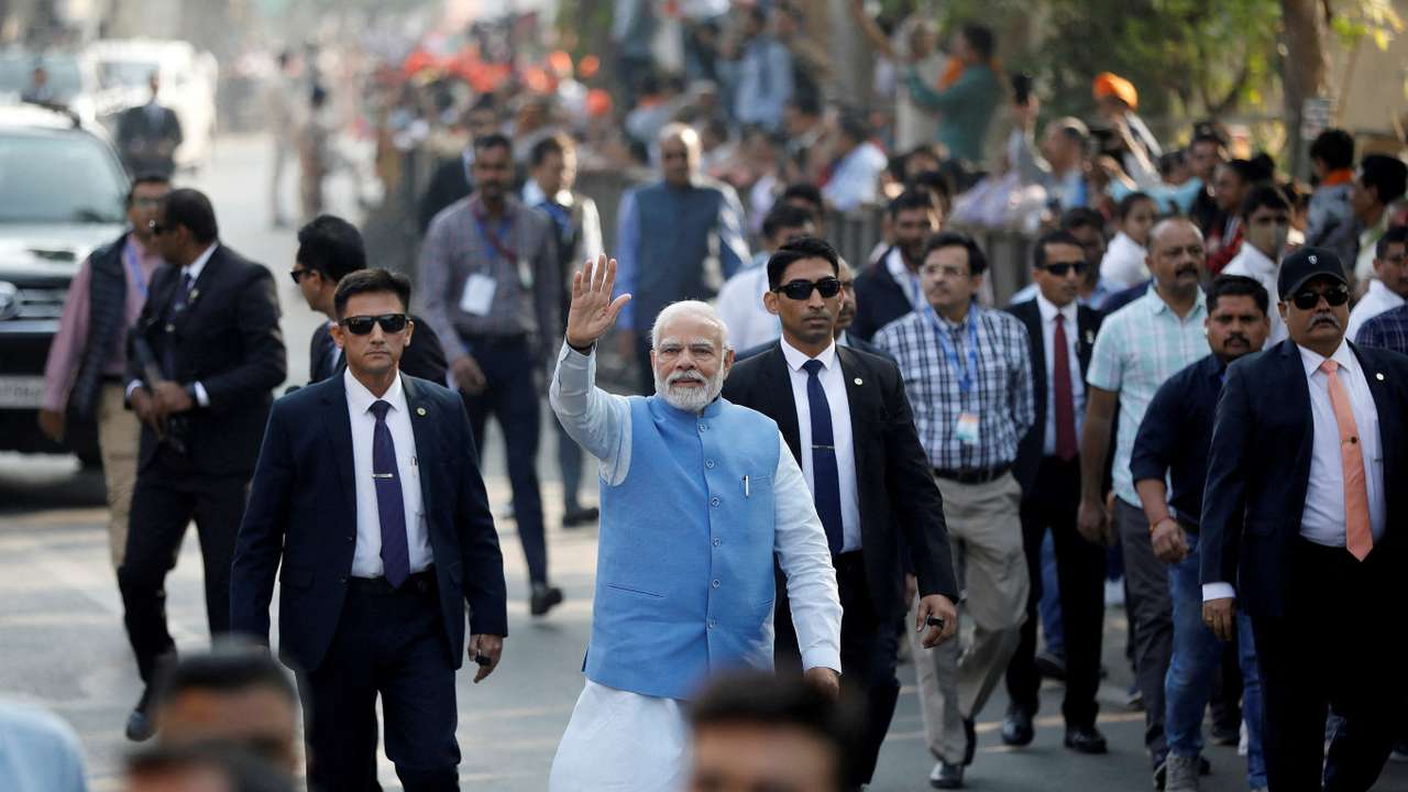 FILE PHOTO: PM Modi waves to his supporters as he arrives to cast his vote, in Ahmedabad