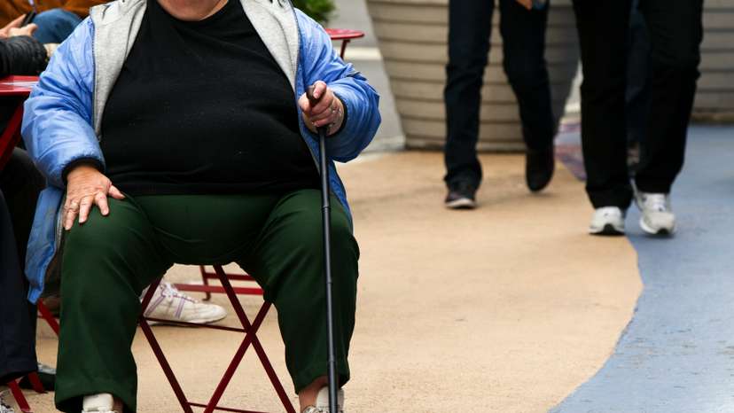 An overweight woman sits on a chair in Times Square in New York