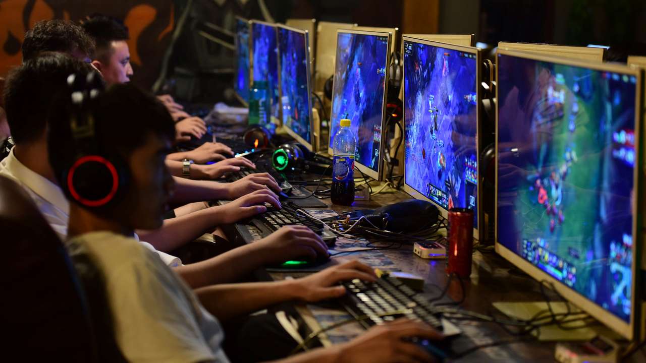 People play online games at an internet cafe in Fuyang