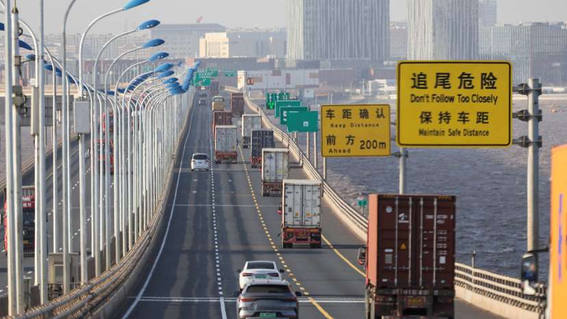 Trucks loaded with shipping containers pass over Donghai Bridge to exit Yangshan Port outside of Shanghai
