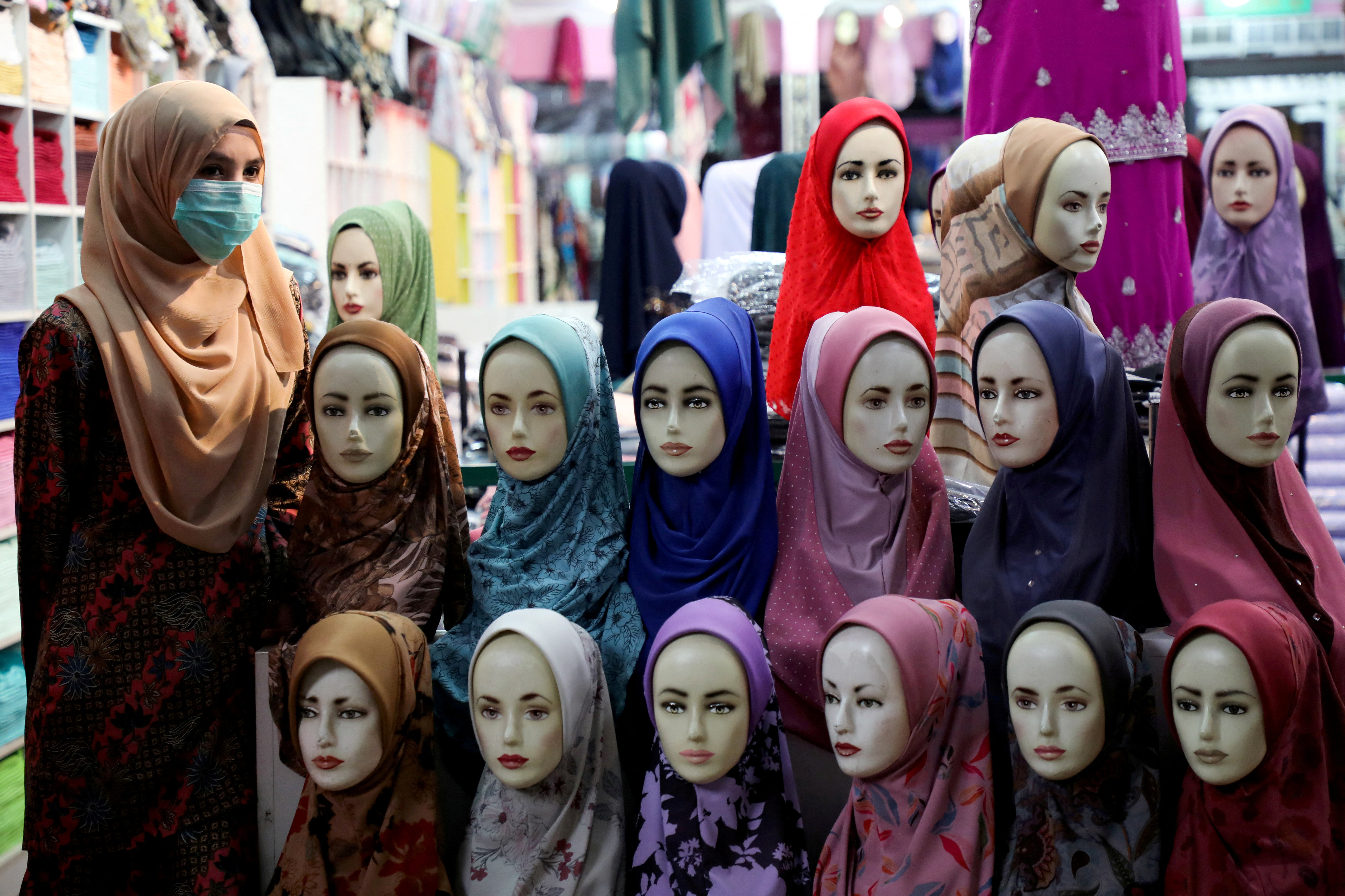FILE PHOTO: A shopkeeper wearing a mask waits for customers at a hijab shop, following the outbreak of the coronavirus in Kuala Lumpur