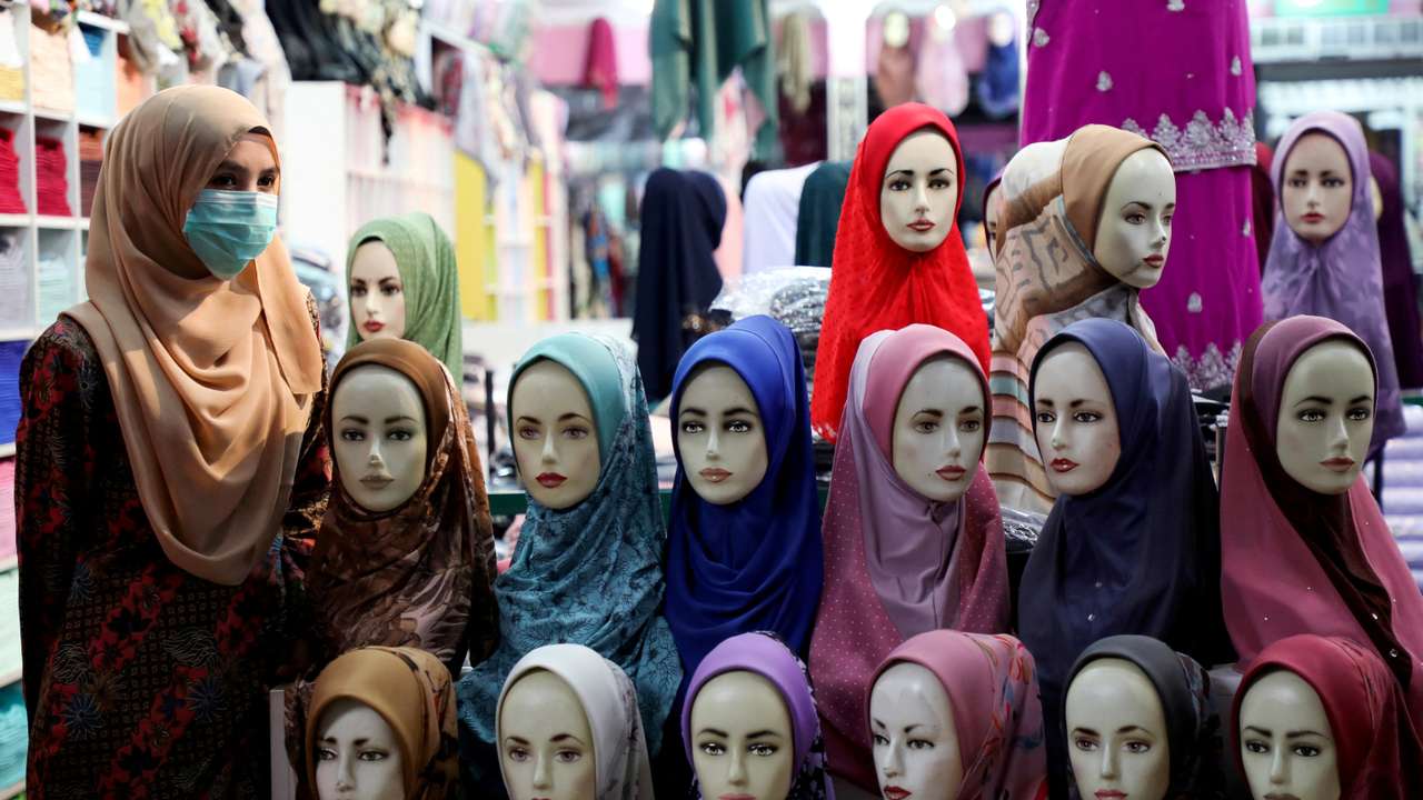 FILE PHOTO: A shopkeeper wearing a mask waits for customers at a hijab shop, following the outbreak of the coronavirus in Kuala Lumpur