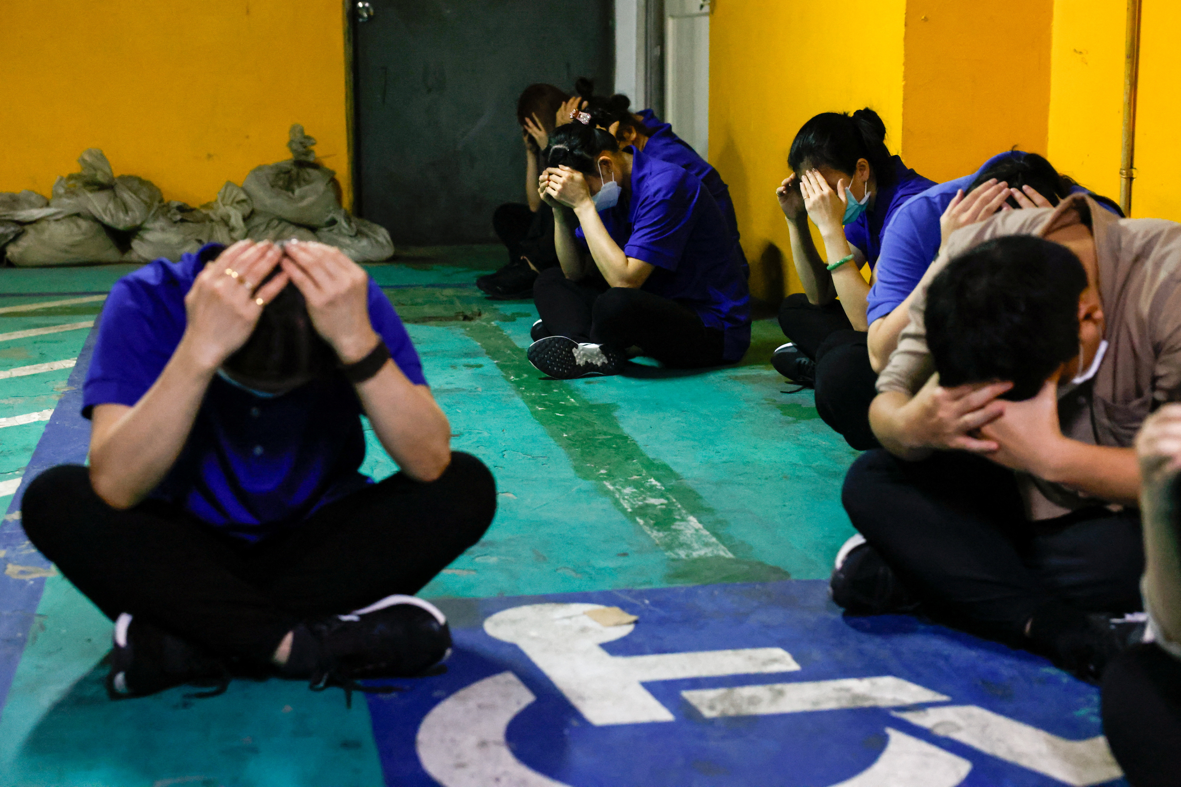 Hotel staff take shelter at the parking lot during an annual air-raid exercise in Hsinchu