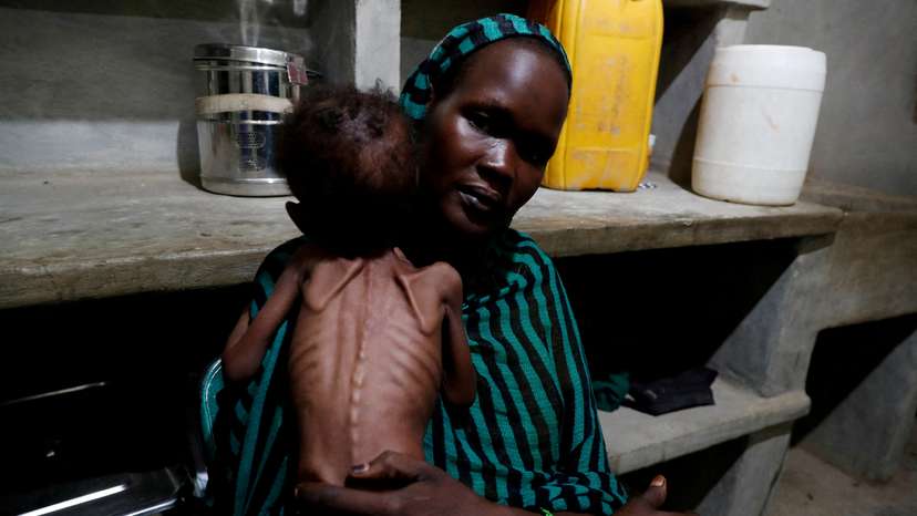 FILE PHOTO: A mother holds her severely malnourished child in South Kordofan, Sudan