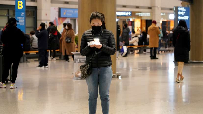 A woman wearing a mask to prevent contracting coronavirus checks her ticket at Incheon International Airport in Incheon