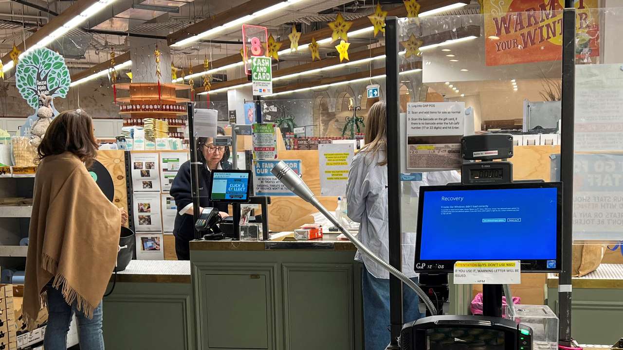 A cash register shows a blue screen at a grocery store affected by a cyber outage in Sydney
