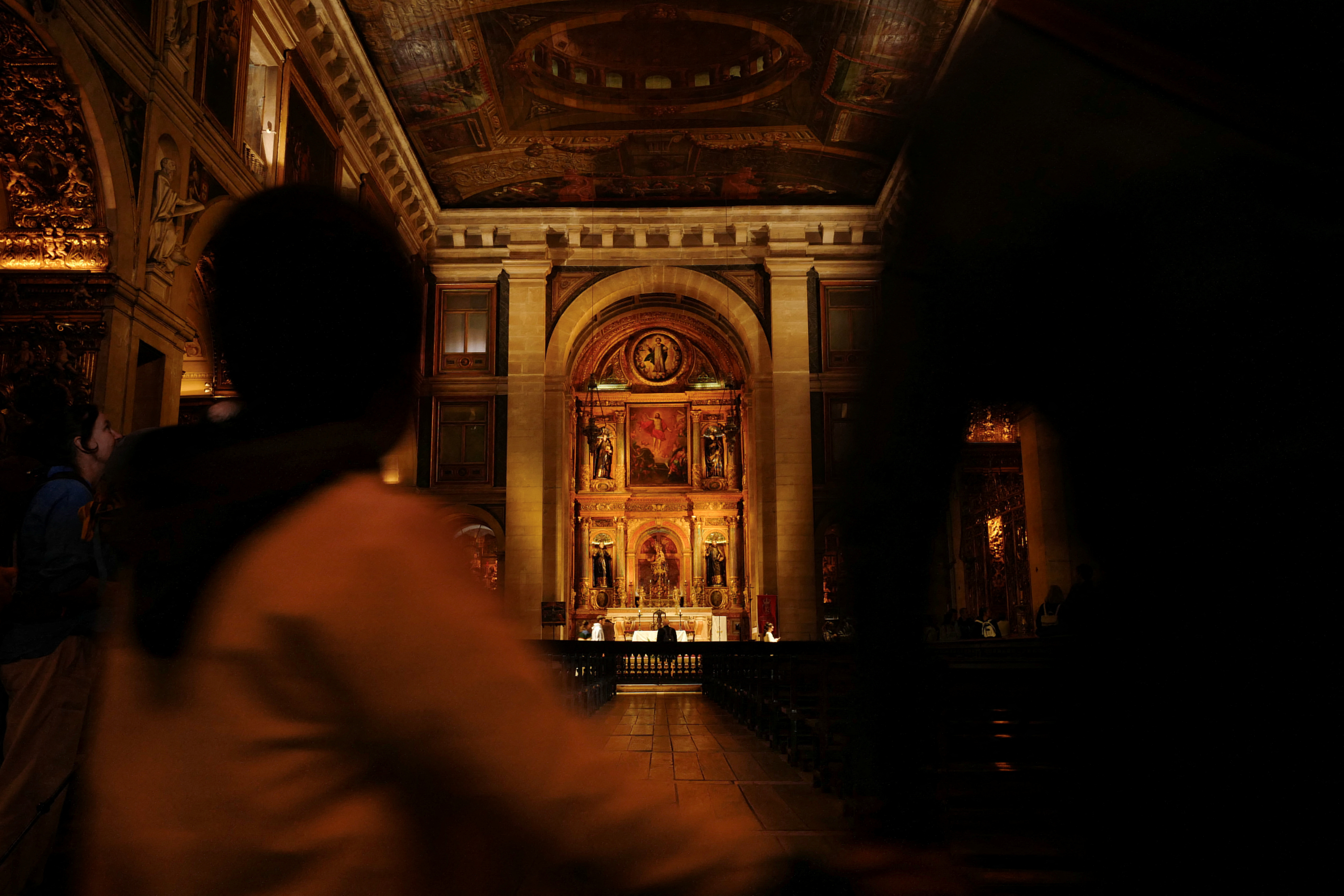 A child passes by while holding an adult hand inside a church in Lisbon