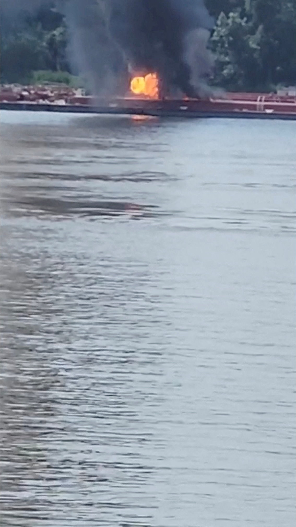 Smoke rises after a helicopter crashed into a barge on the Mississippi River in Alton